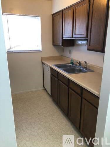 A kitchen with brown cabinets and a white sink.