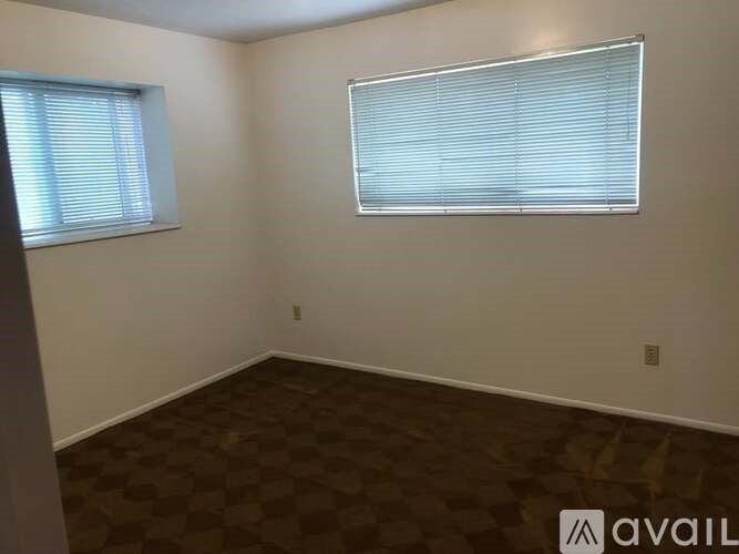 A room with a checkered floor and a window with blinds.
