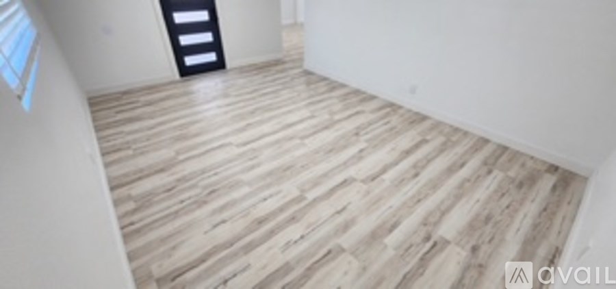 A room with wooden flooring and a ladder in the corner.