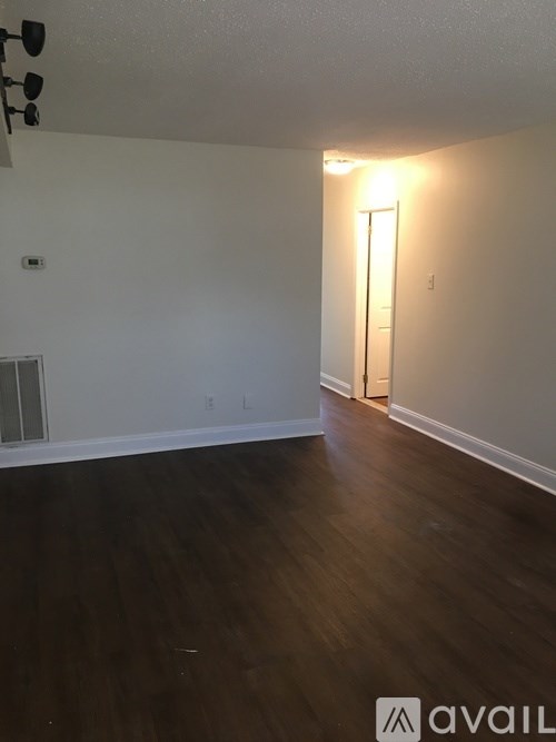 A room with wooden floors and a light on the wall.