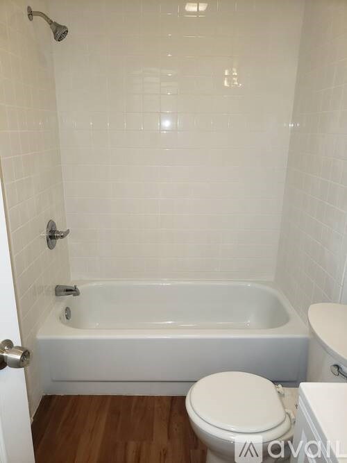 A white bathroom with a toilet, tub, and shower.