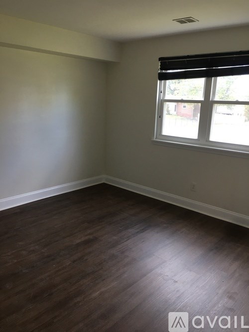 A room with a window and wooden flooring.