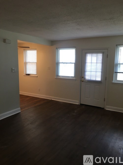 A room with wooden floors and two doors.