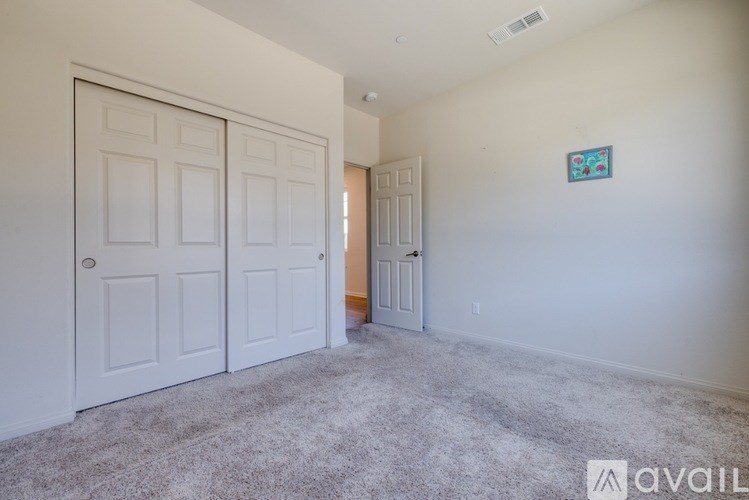 A room with two doors and a carpeted floor.
