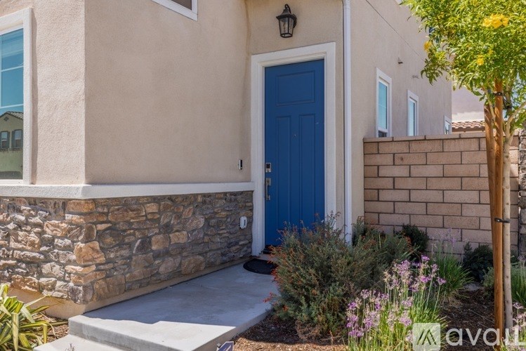A house with a blue door and a stone wall.