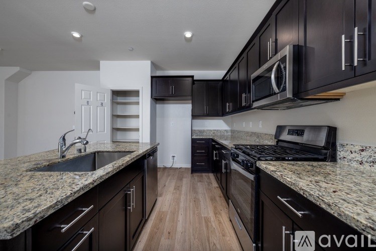 A kitchen with black cabinets and granite countertops.