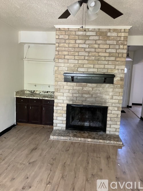 A brick fireplace with a fan above it.