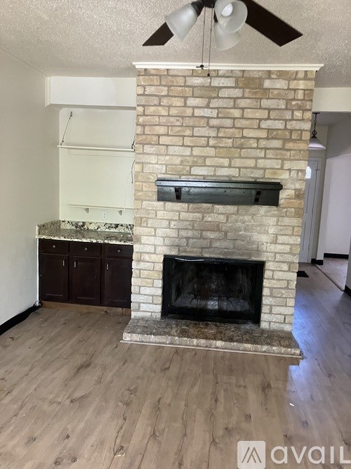 A brick fireplace with a fan above it.