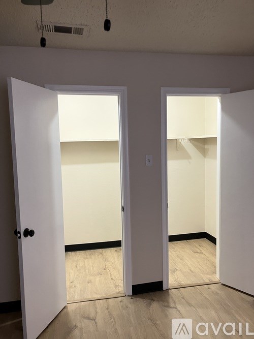 Two white doors open to empty rooms.