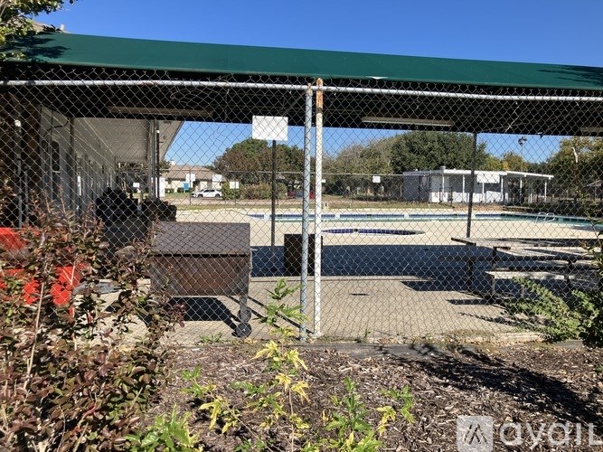 A green metal fence surrounds a pool area.