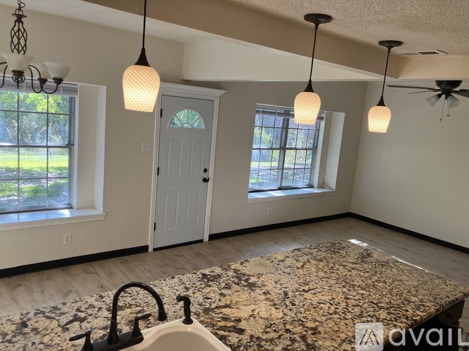 A room with a granite countertop and a ceiling fan.
