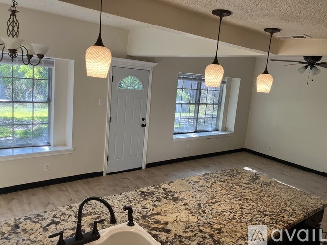 A room with a granite countertop and a ceiling fan.