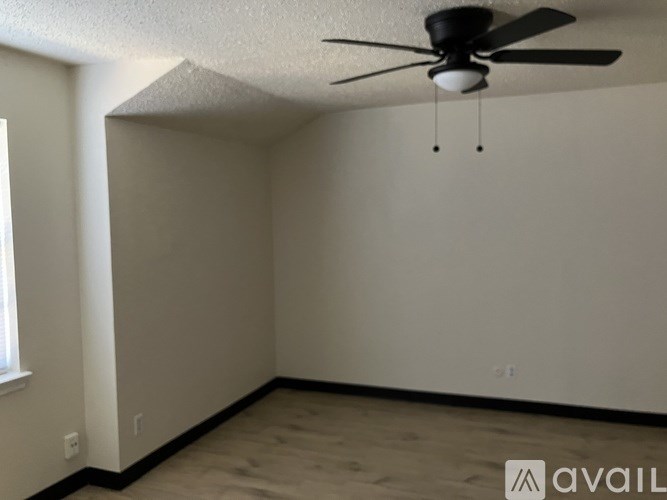 A room with a ceiling fan and a window.