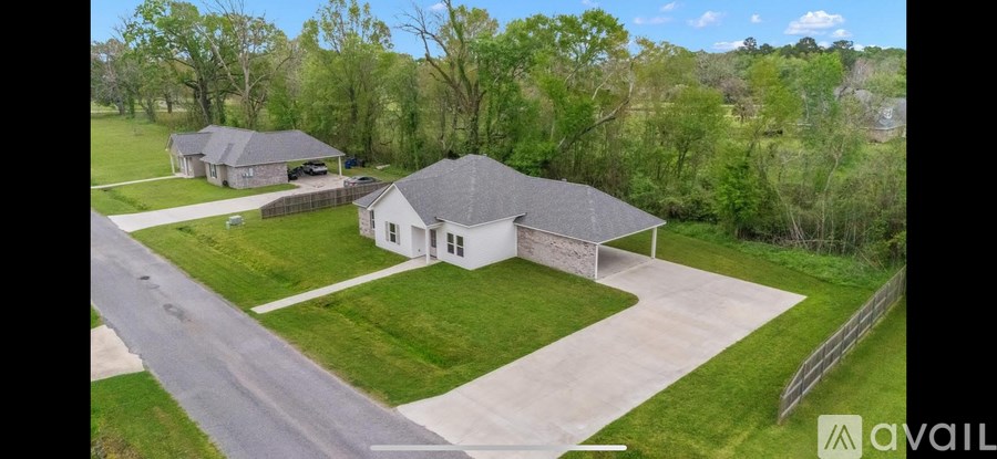 A house with a driveway and a lawn in front of it.