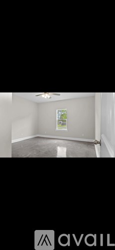 A room with a poster on the wall and a ceiling fan.