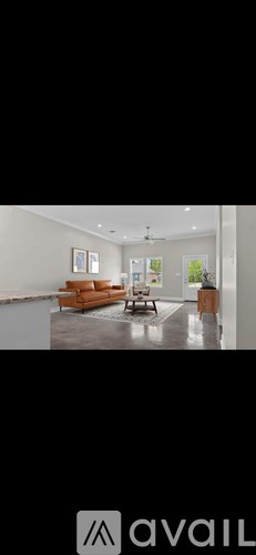 A modern living room with a brown leather sofa and a coffee table.