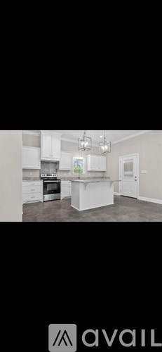 A modern kitchen with white cabinets and a large island.
