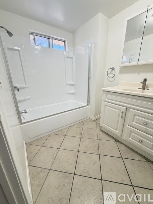 A white bathroom with a walk-in shower and a sink.