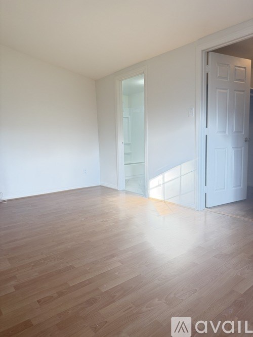 A room with wooden flooring and a white door.