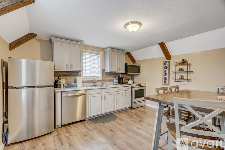 A kitchen with a refrigerator, sink, and cabinets.