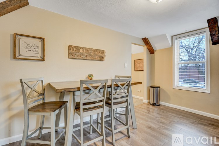 A dining room with a wooden table and chairs.