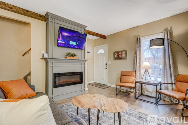 A living room with a fireplace and a television on the wall.