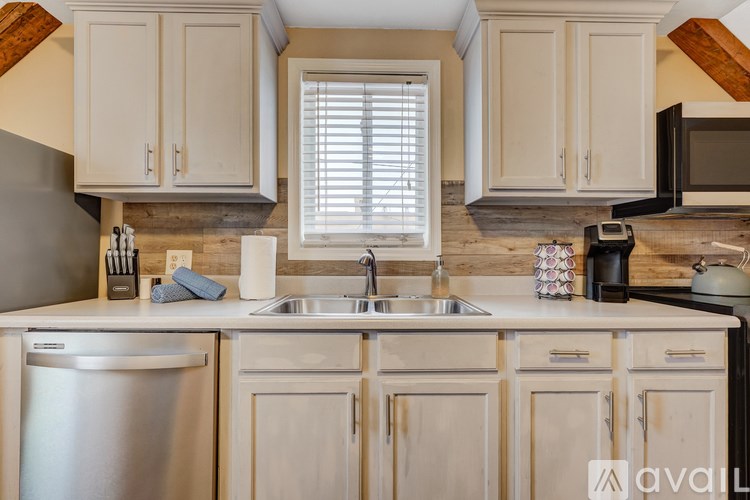 A kitchen with white cabinets and a stainless steel dishwasher.