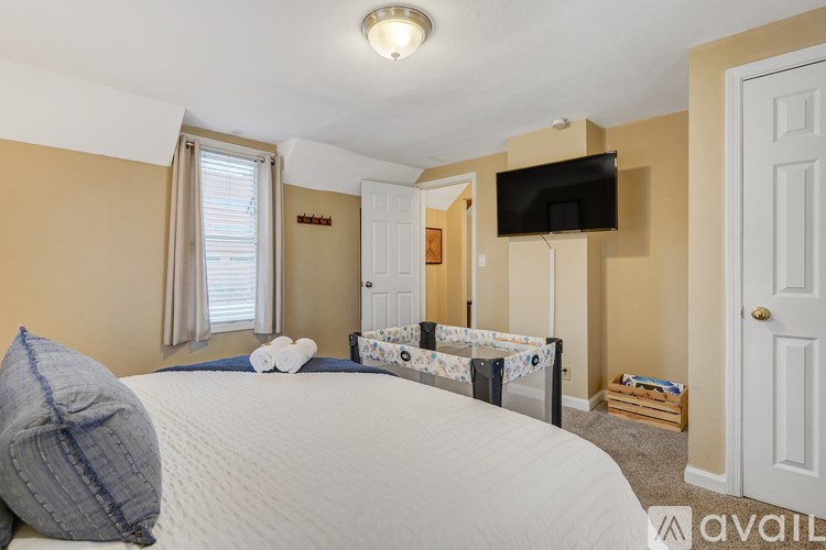 A bedroom with a large bed and a flat screen TV mounted on the wall.