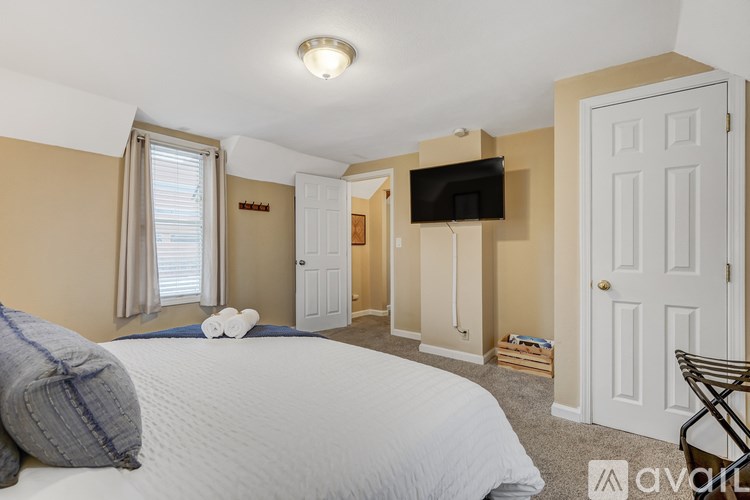 A bedroom with a large bed and a flat screen TV mounted on the wall.