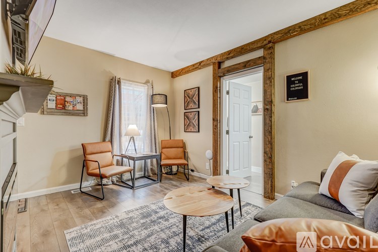 A living room with a grey sofa, a wooden coffee table, and a white door.
