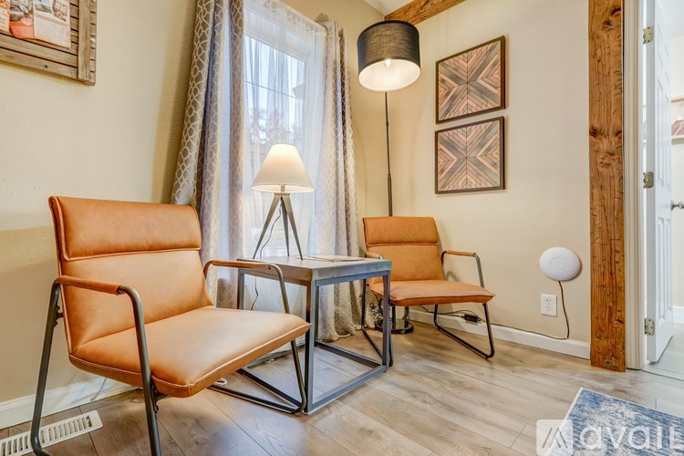 A living room with a brown leather chair and a metal table.