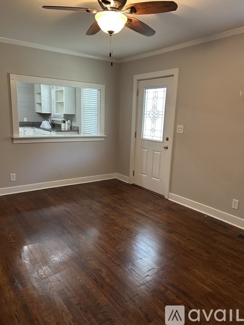 A room with a wooden floor and a ceiling fan.