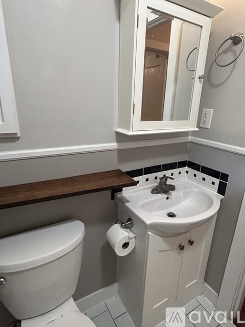 A white toilet sits next to a white sink in a bathroom.