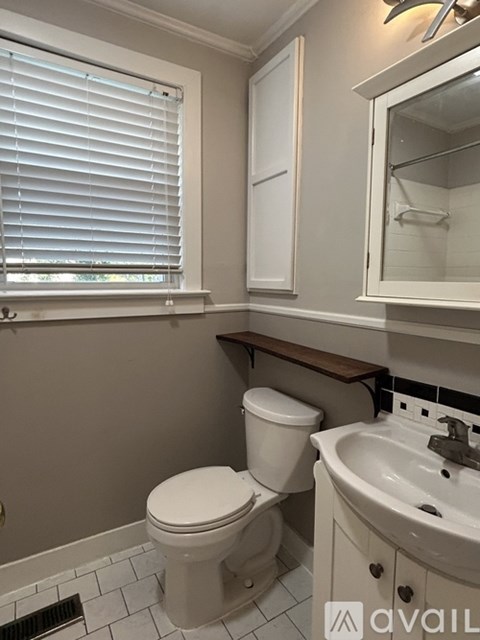 A white toilet sits next to a sink in a bathroom.