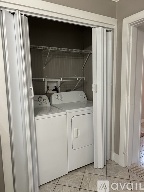 A white laundry room with a washer and dryer.