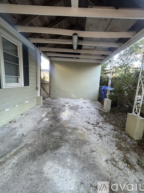 A patio with a concrete floor and a white wall.