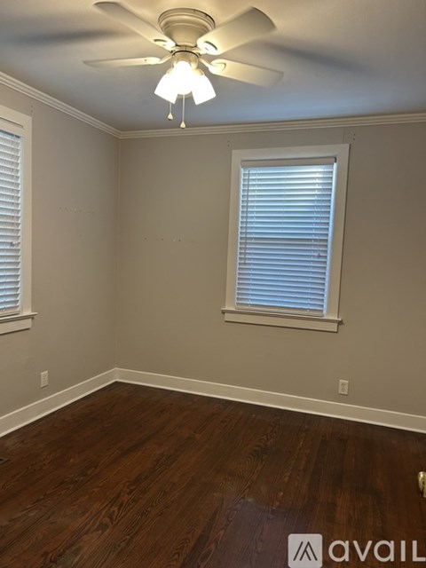A room with a ceiling fan and a window with blinds.