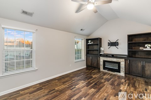 A living room with wood flooring and a fireplace.