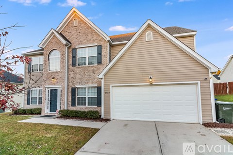 A two-story house with a garage and a driveway.