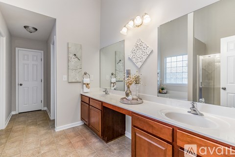A bathroom with a vanity, sink, and mirror.