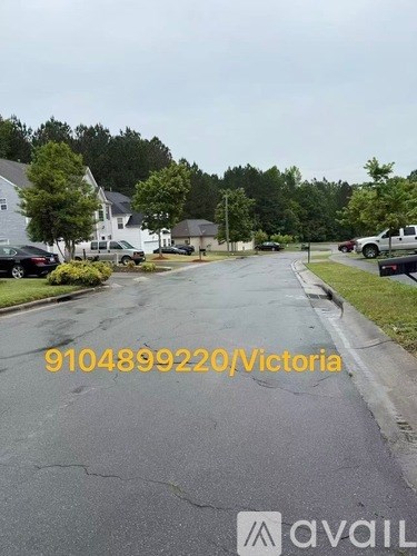 A street view with a house and cars parked on the side.