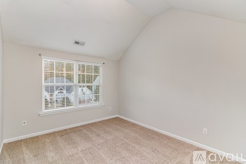 A room with a window and carpeted floor.