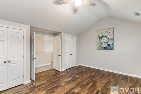 A room with wooden floors and a ceiling fan.