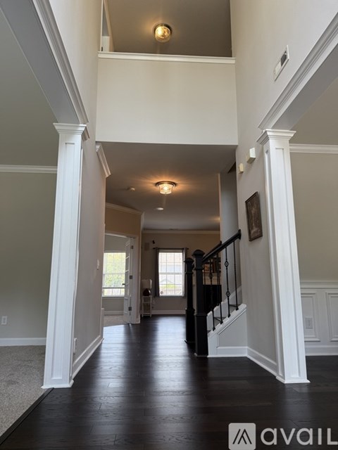 A hallway with a staircase and a painting on the wall.