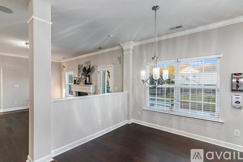 A well-lit, spacious room with a window and a chandelier.