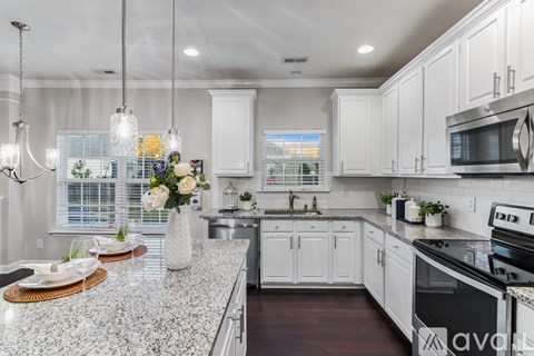 A kitchen with white cabinets and a granite countertop.