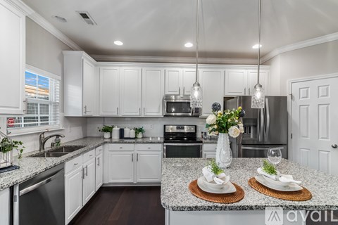 A modern kitchen with white cabinets and a central island.