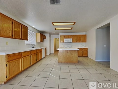 A kitchen with wooden cabinets and a countertop is available for rent.