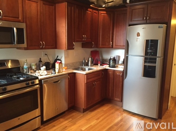 A kitchen with wooden cabinets and a stainless steel refrigerator.