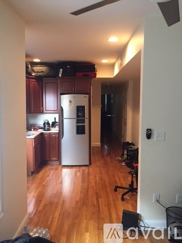 A kitchen with wooden floors and a white refrigerator.